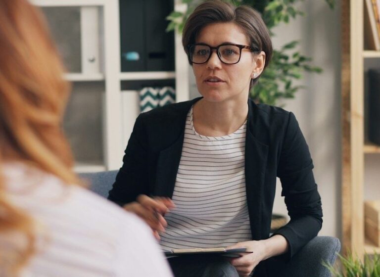 Therapeut en cliënt voeren een rustig gesprek in een behandelruimte